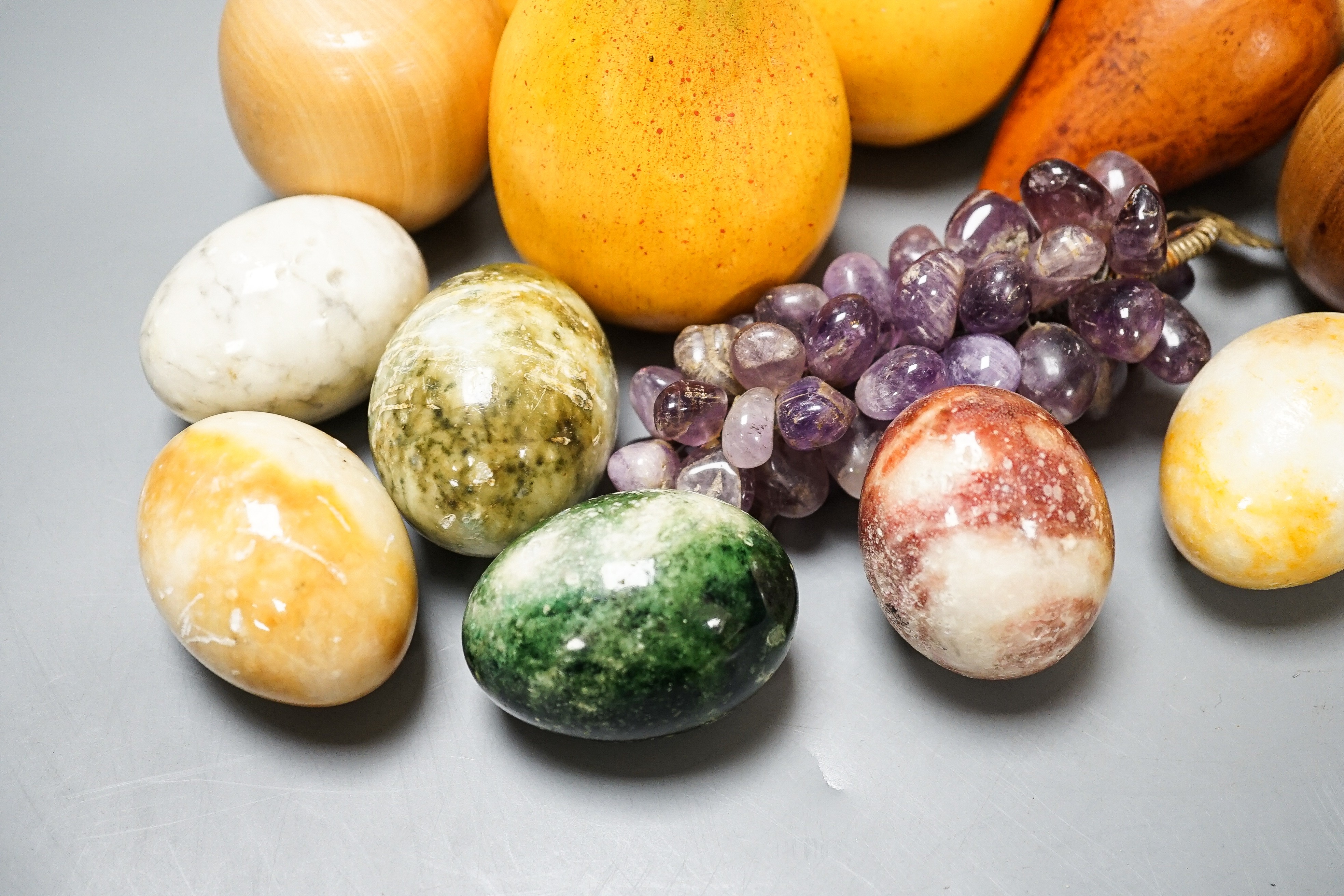 A group of polished stone and wood models of fruit, eggs, et.